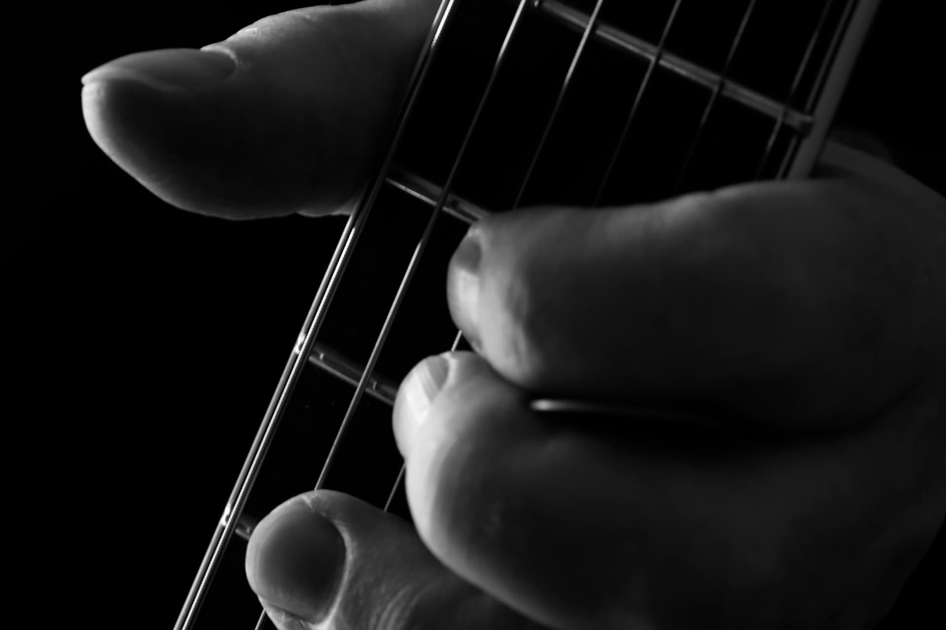 Fingers fretting strings close-up
